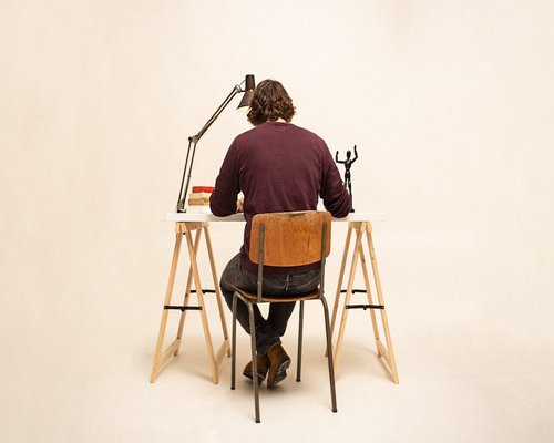 Person adjusting desk lamp for better workspace lighting