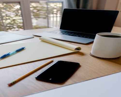Organized home office desk with a coffee mug and a laptop